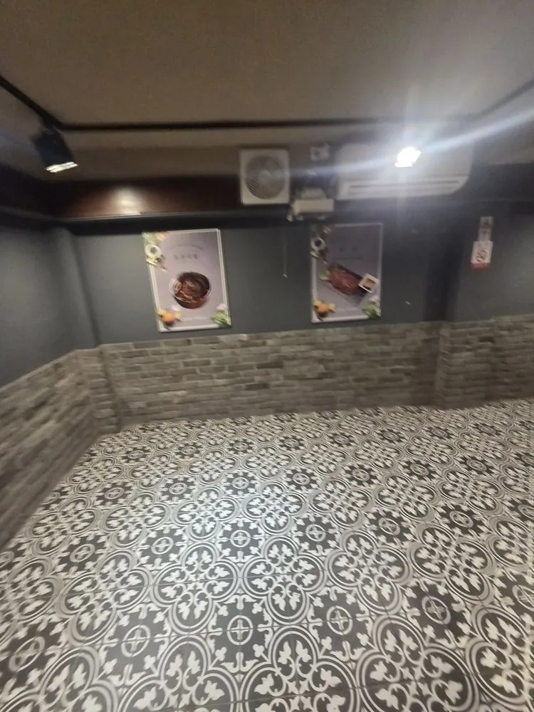 무늬 타일 바닥과 벽면 타일이 보이는 음식점 내부